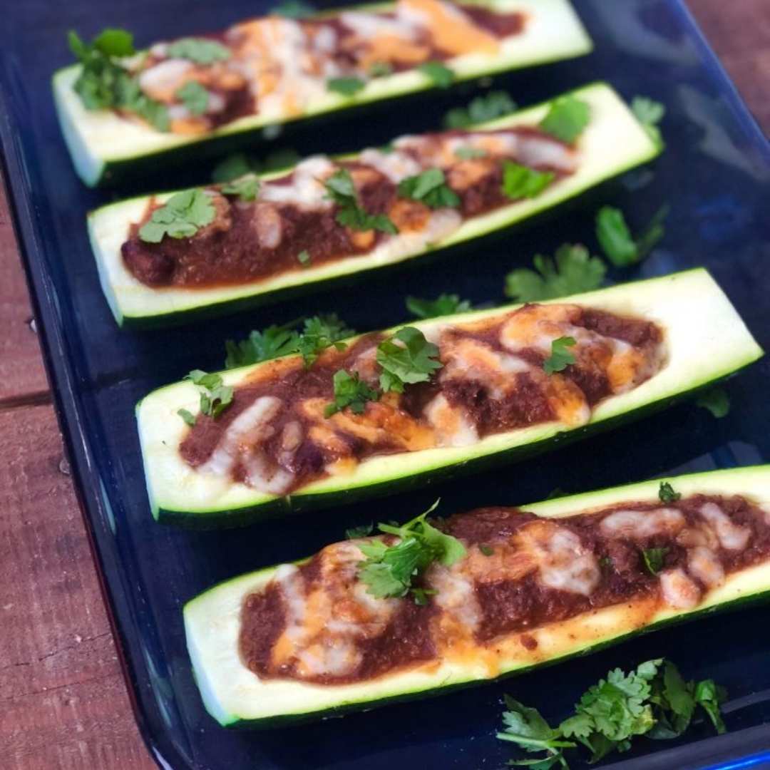 Recette de bateaux de courgettes farcis au chili, cuits au four. Recette faible en glucides et riche en protéines pour un repas minceur. Une création de la Clinique Maigrir en Santé.